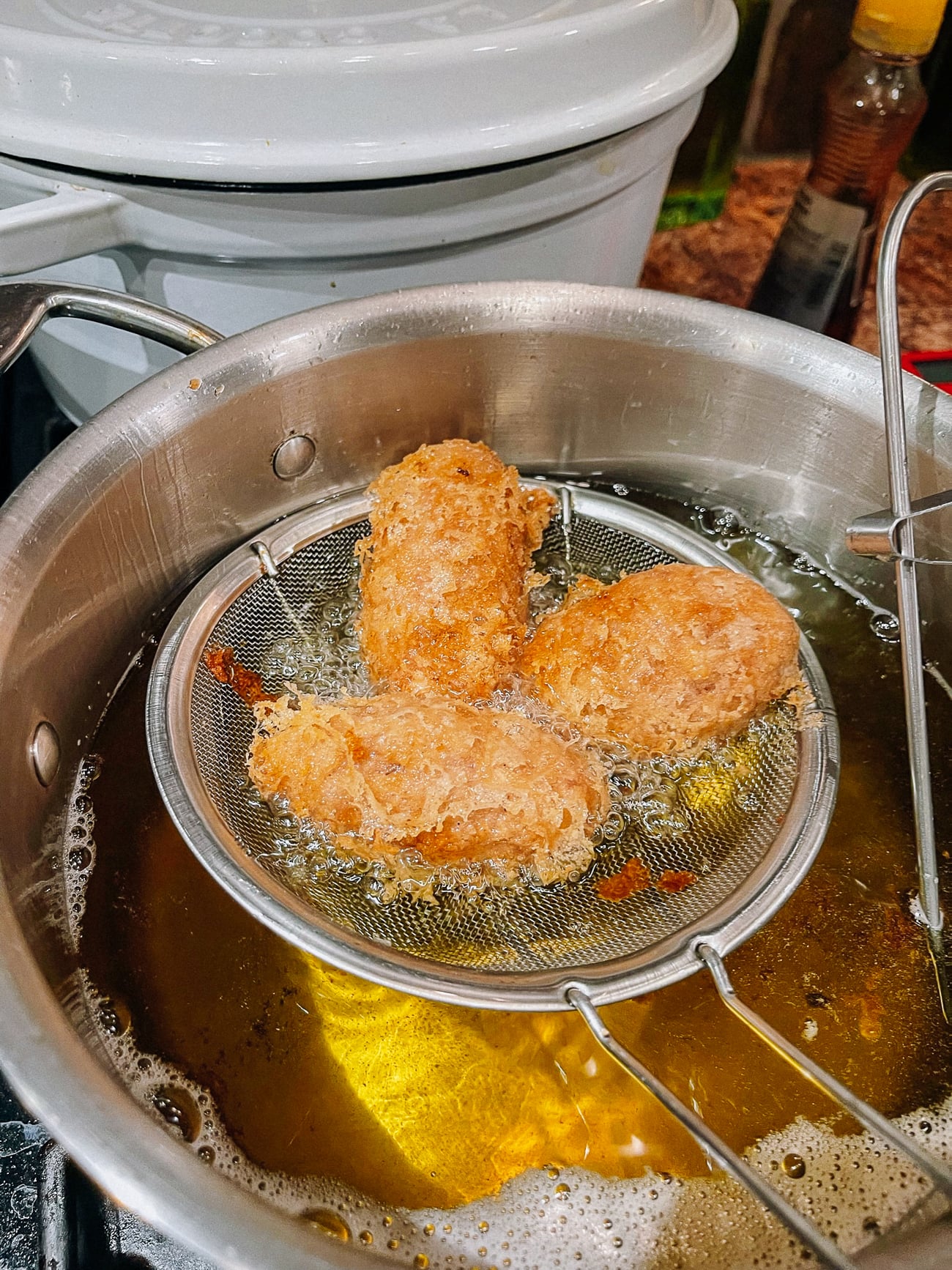 Eddie frying taro puffs in oil