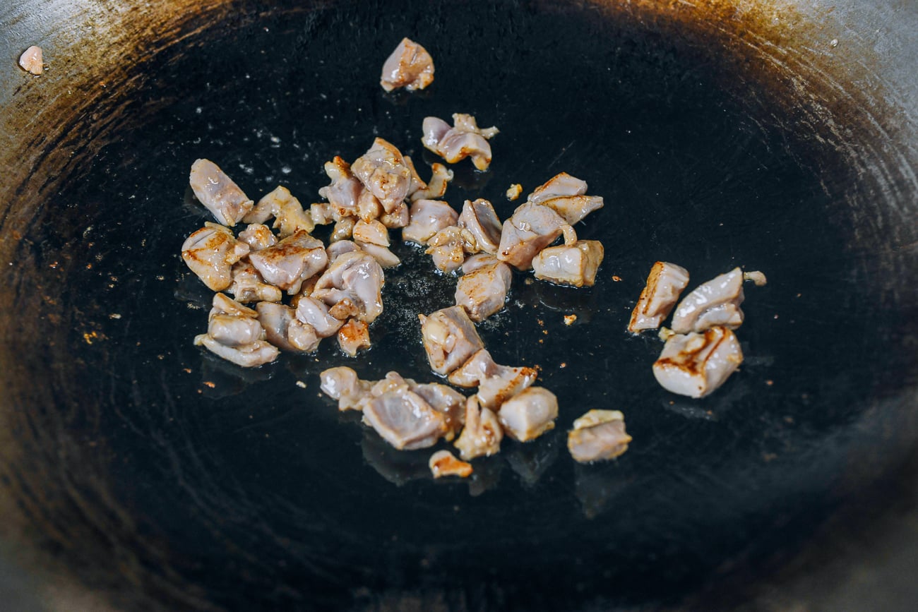 Searing boneless chicken thigh pieces in wok