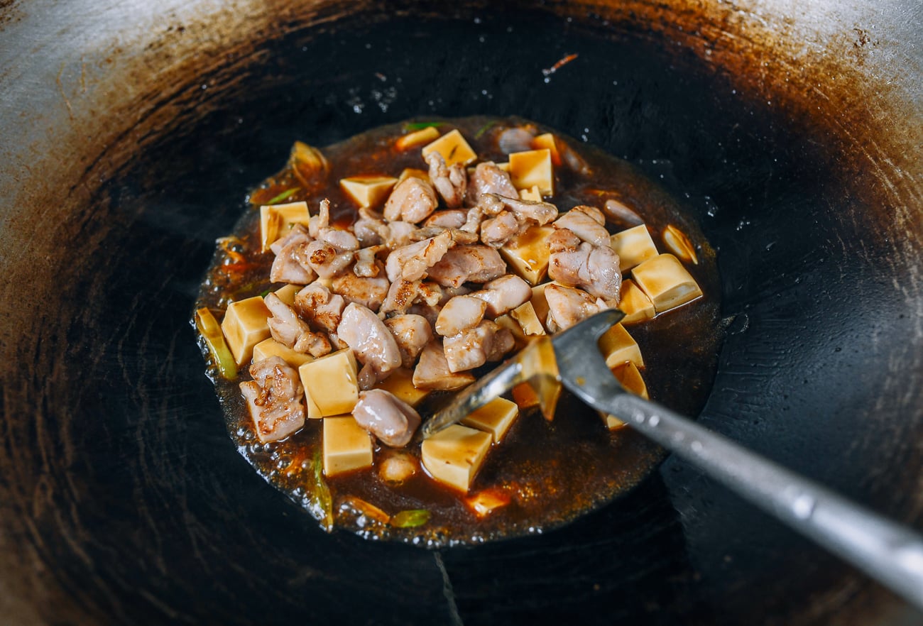Adding chicken to tofu in wok
