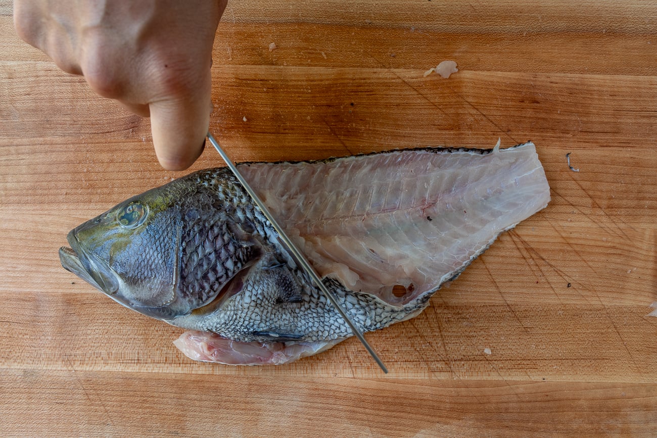 Removing head from fish