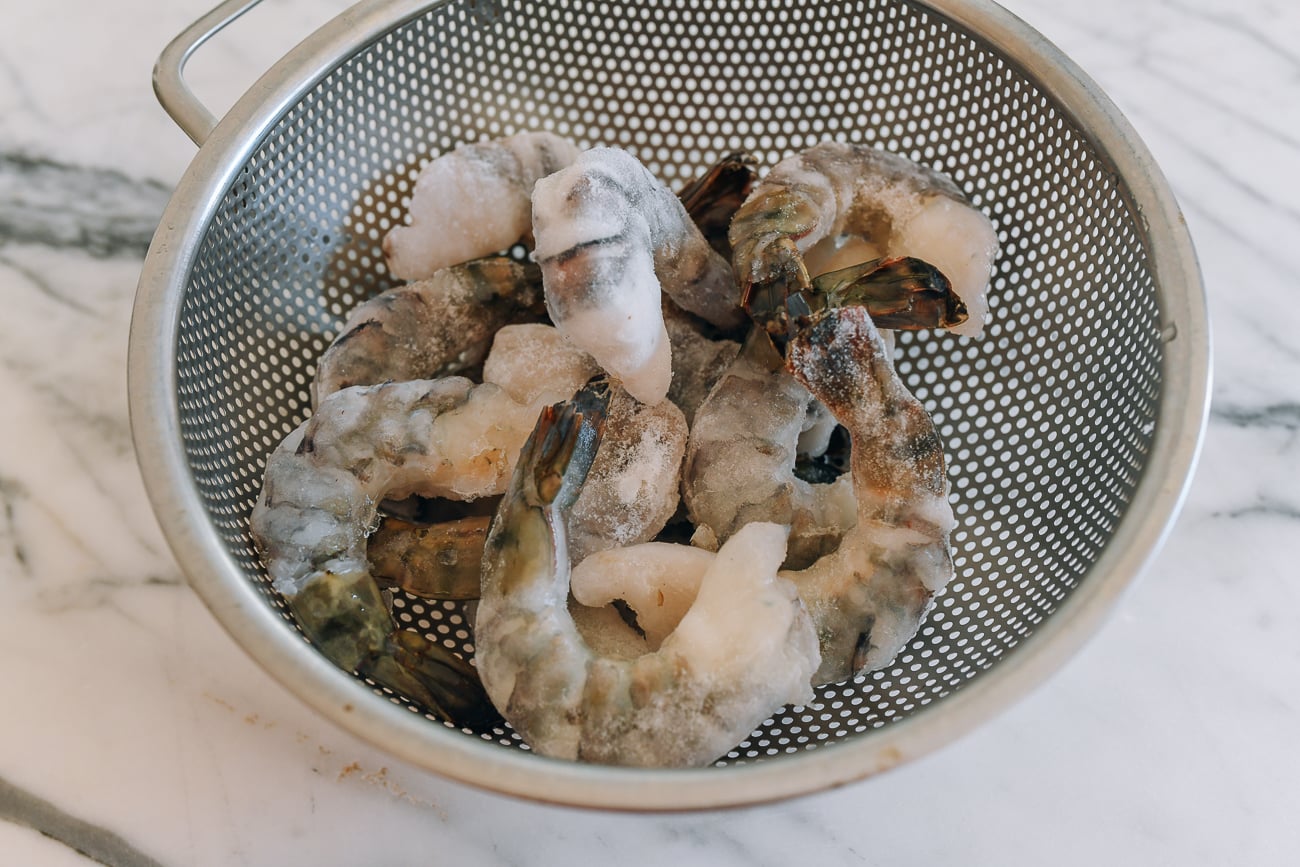 Frozen tiger shrimp in metal colander