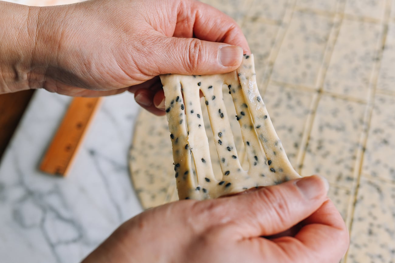 Stretching cut sesame dough with hands