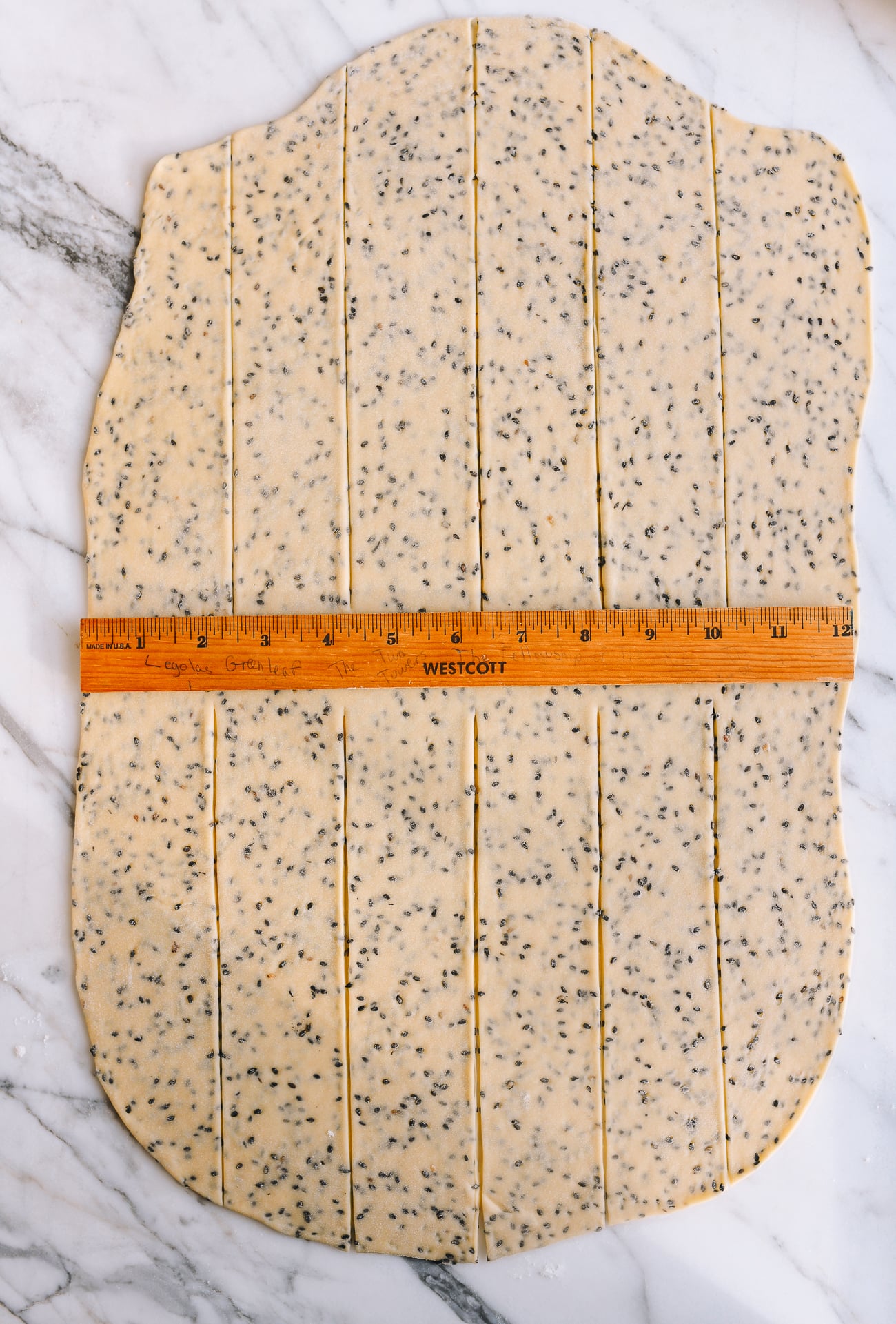Sesame dough cut into strips with ruler
