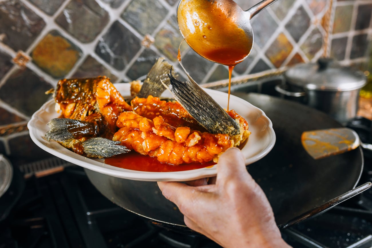 ladling sauce on top of fish