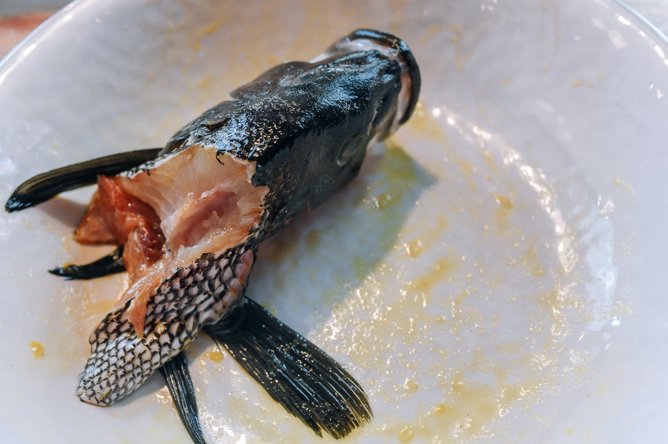 spreading fish head in egg yolk mixture