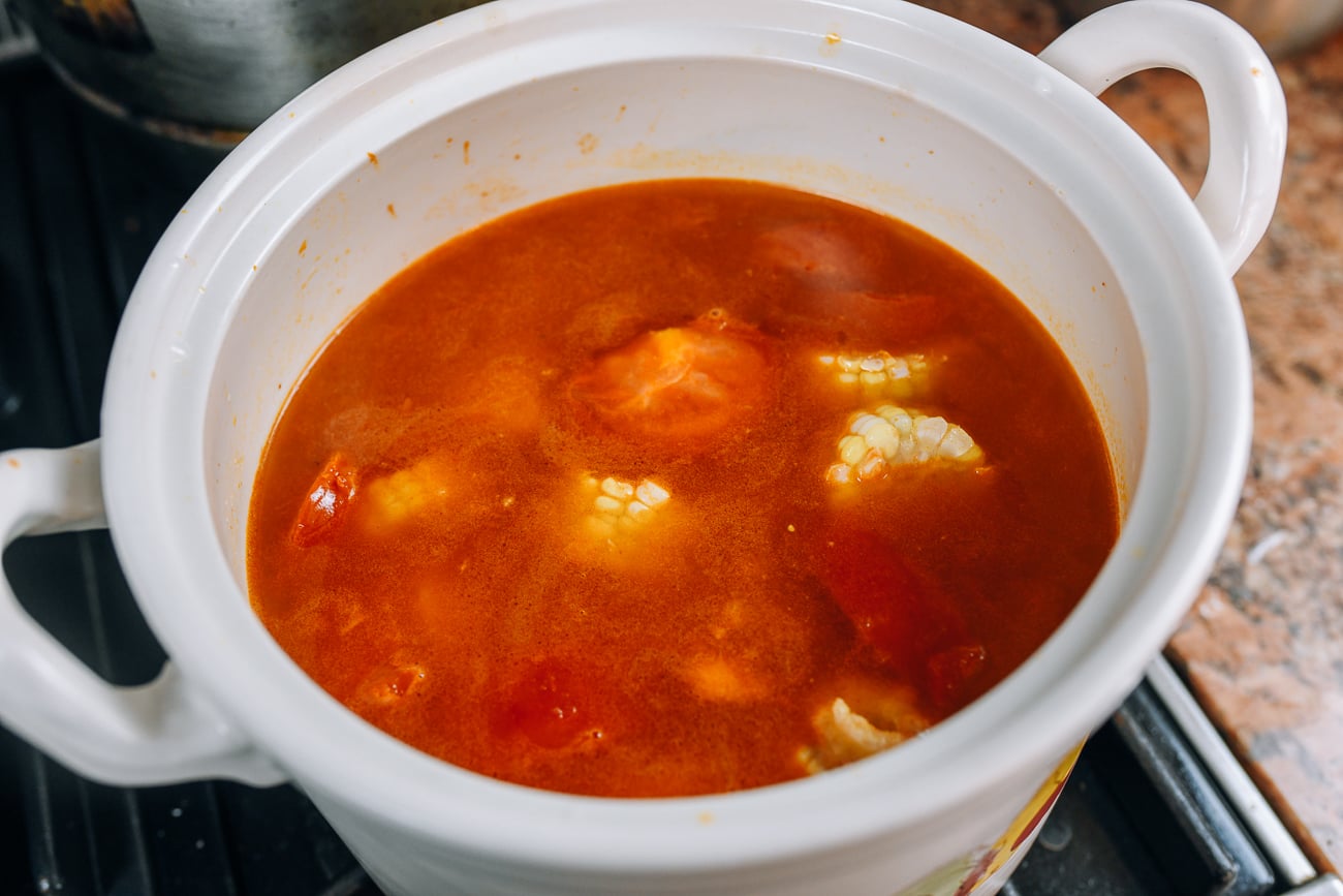 Soup broth with tomatoes, corn, and pork bones
