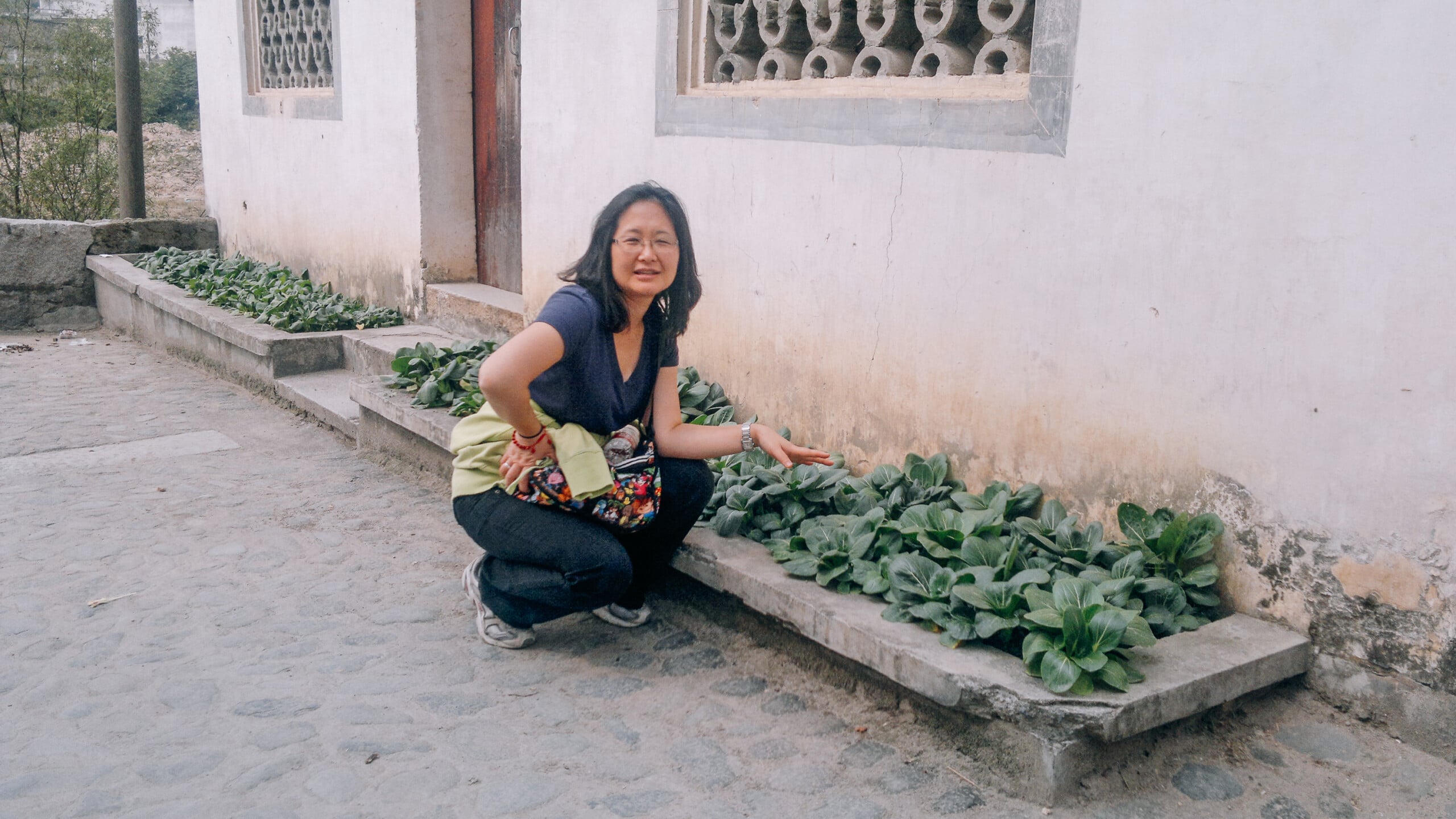 Judy next to bok choy garden
