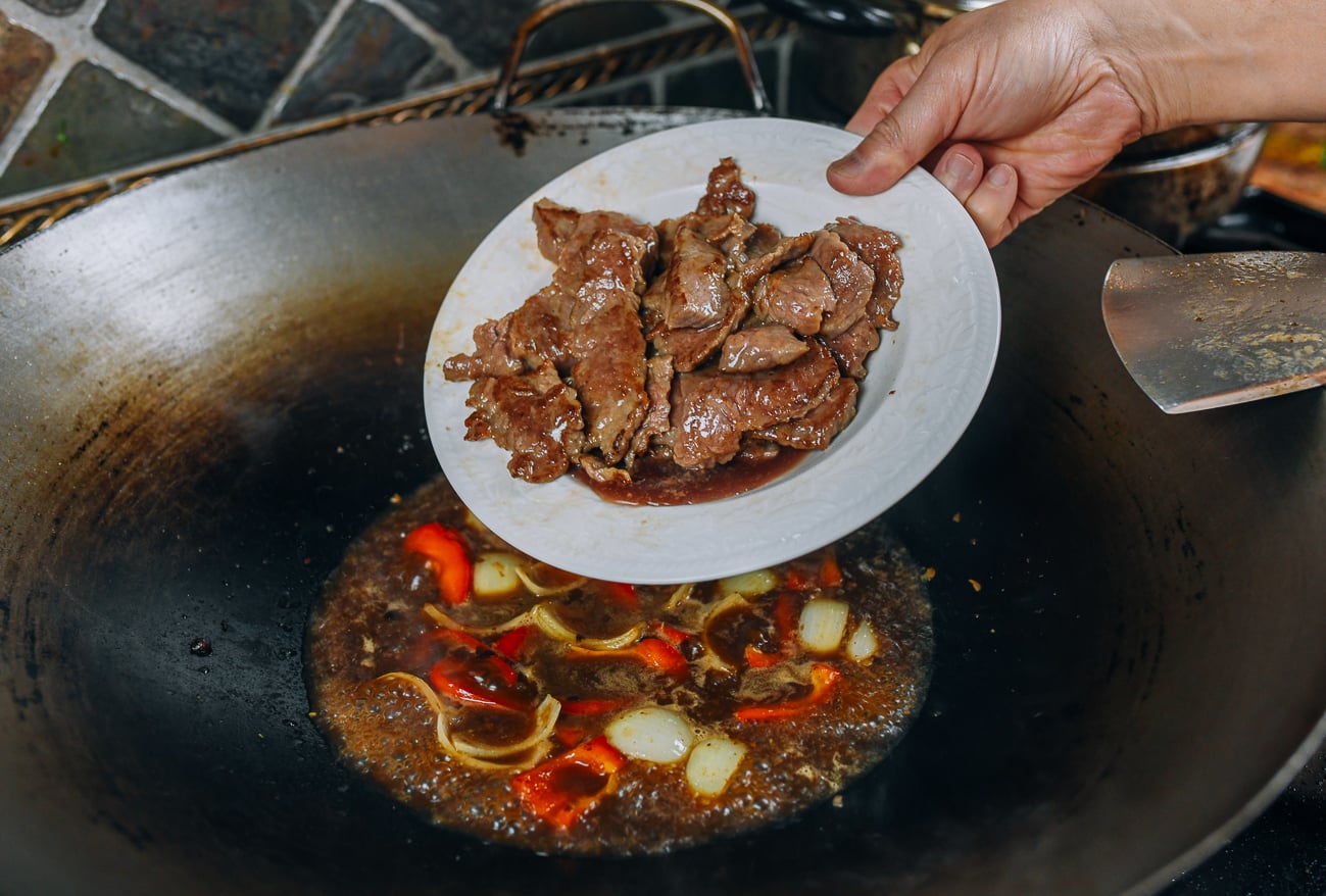 adding beef back to wok