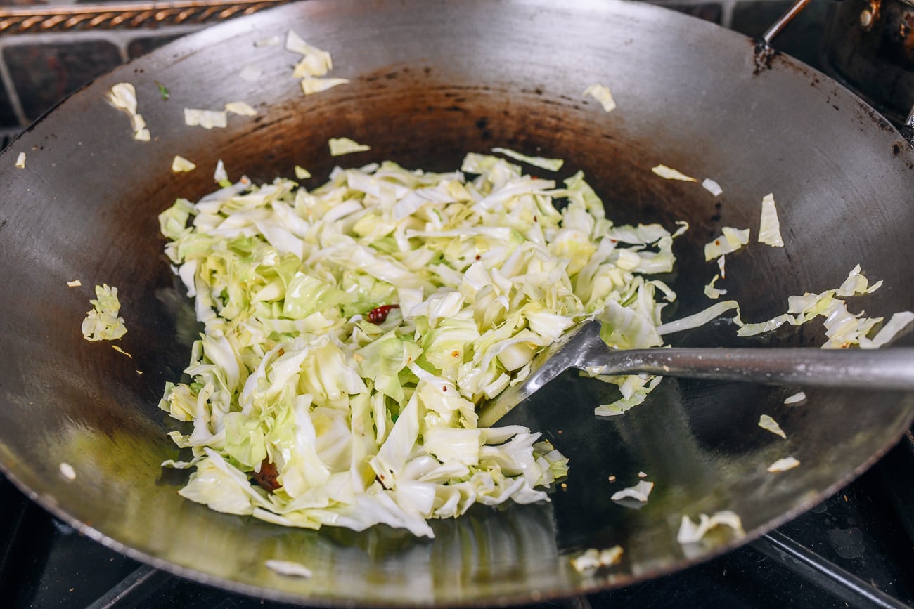 stir-frying cabbage in wok