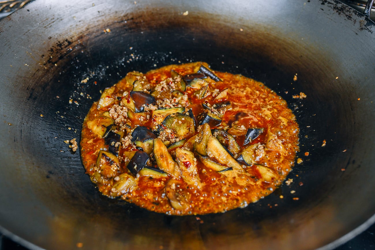 cooking mapo eggplant in wok