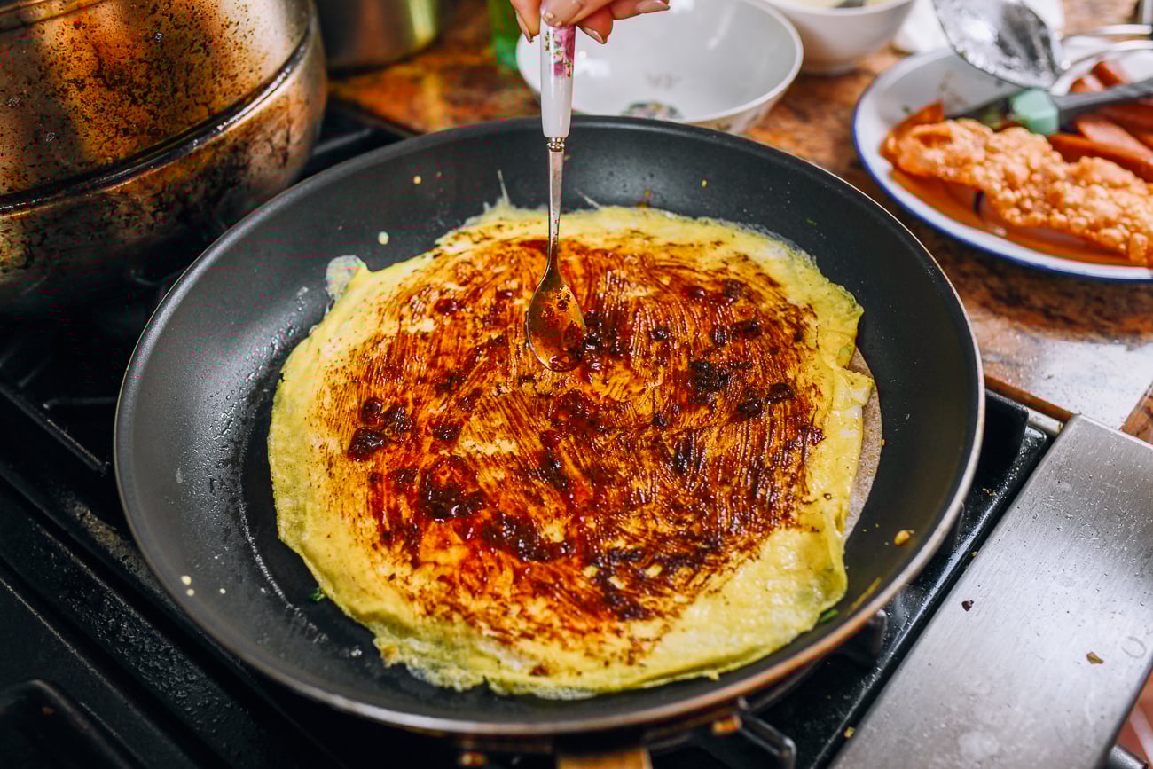 spreading spicy bean sauce on egg