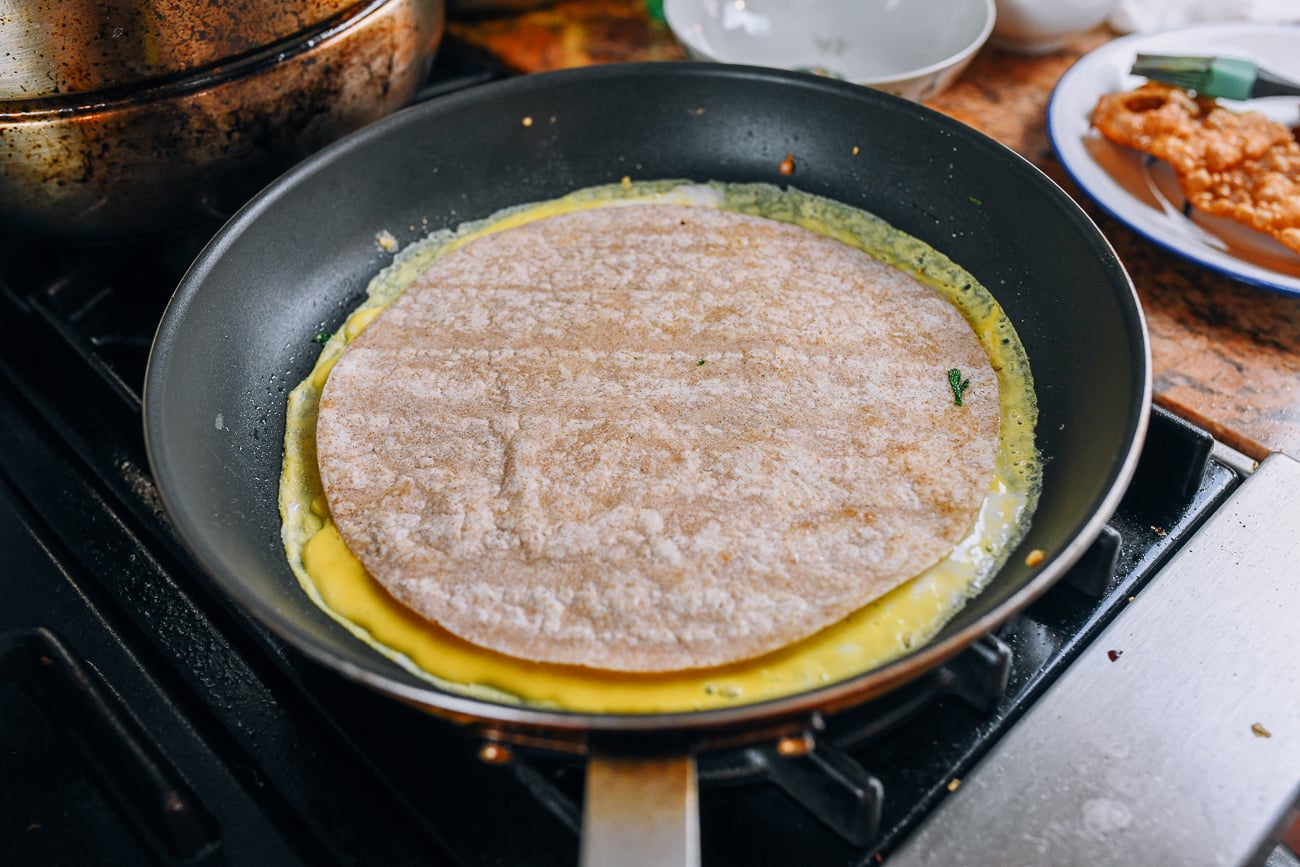 adding tortilla on top of egg