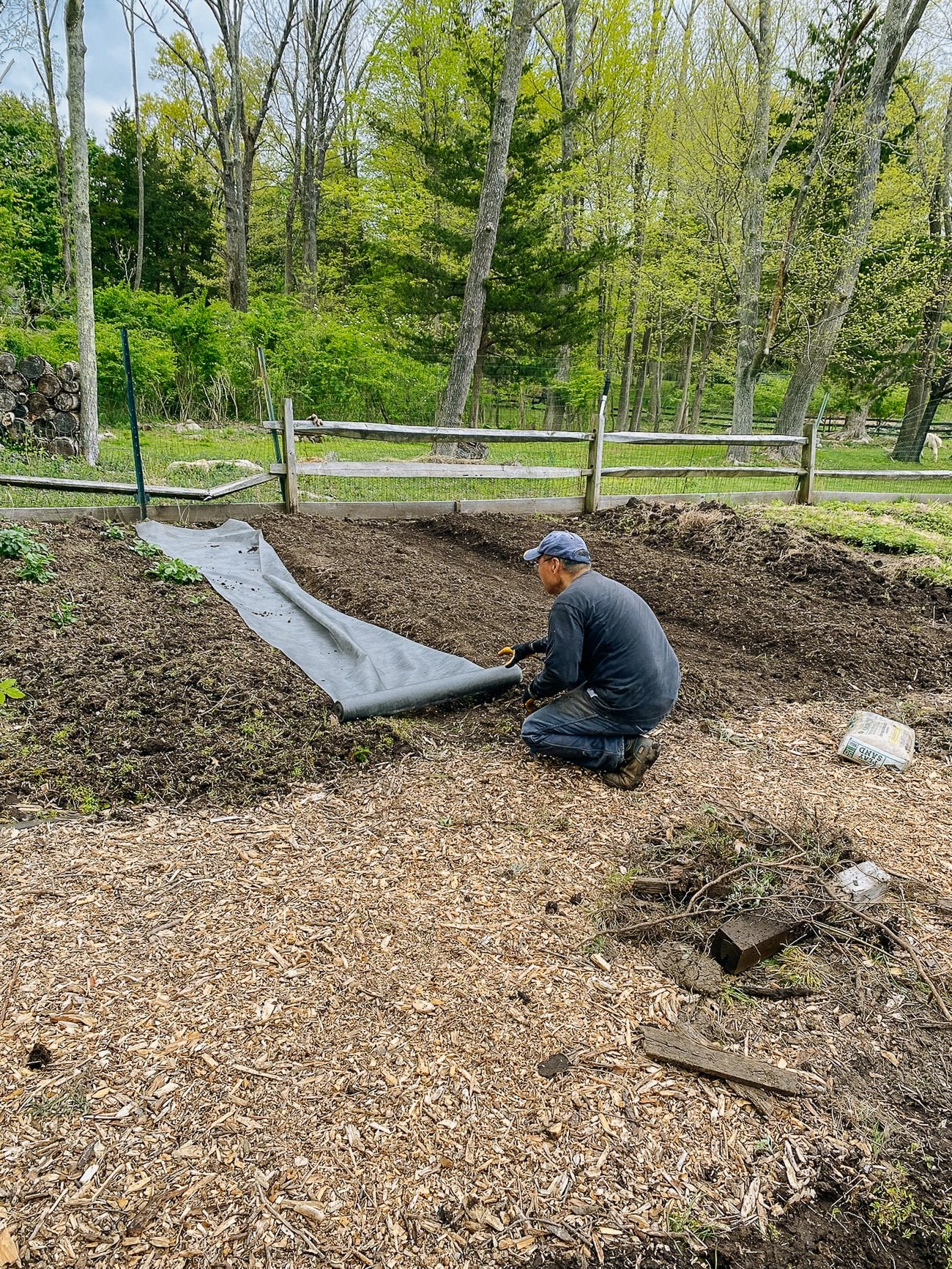 Placing weed blocking fabric in walkways between garden beds