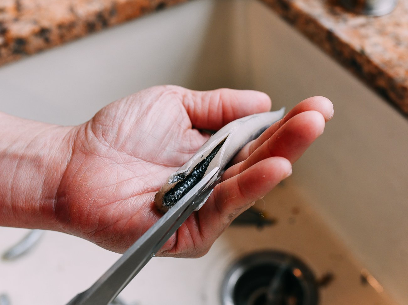 slicing open belly of smelt