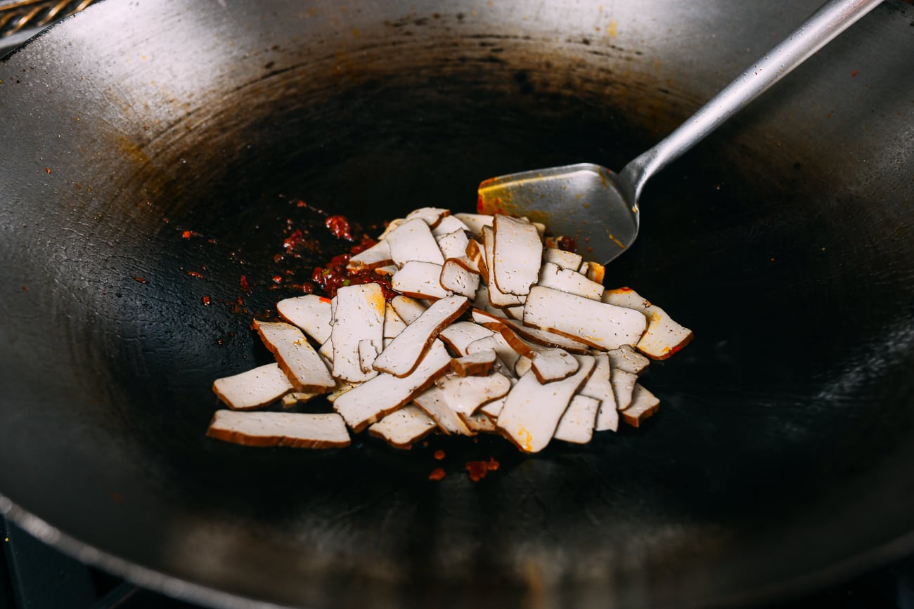 Adding blanched tofu to spicy sauce mixture