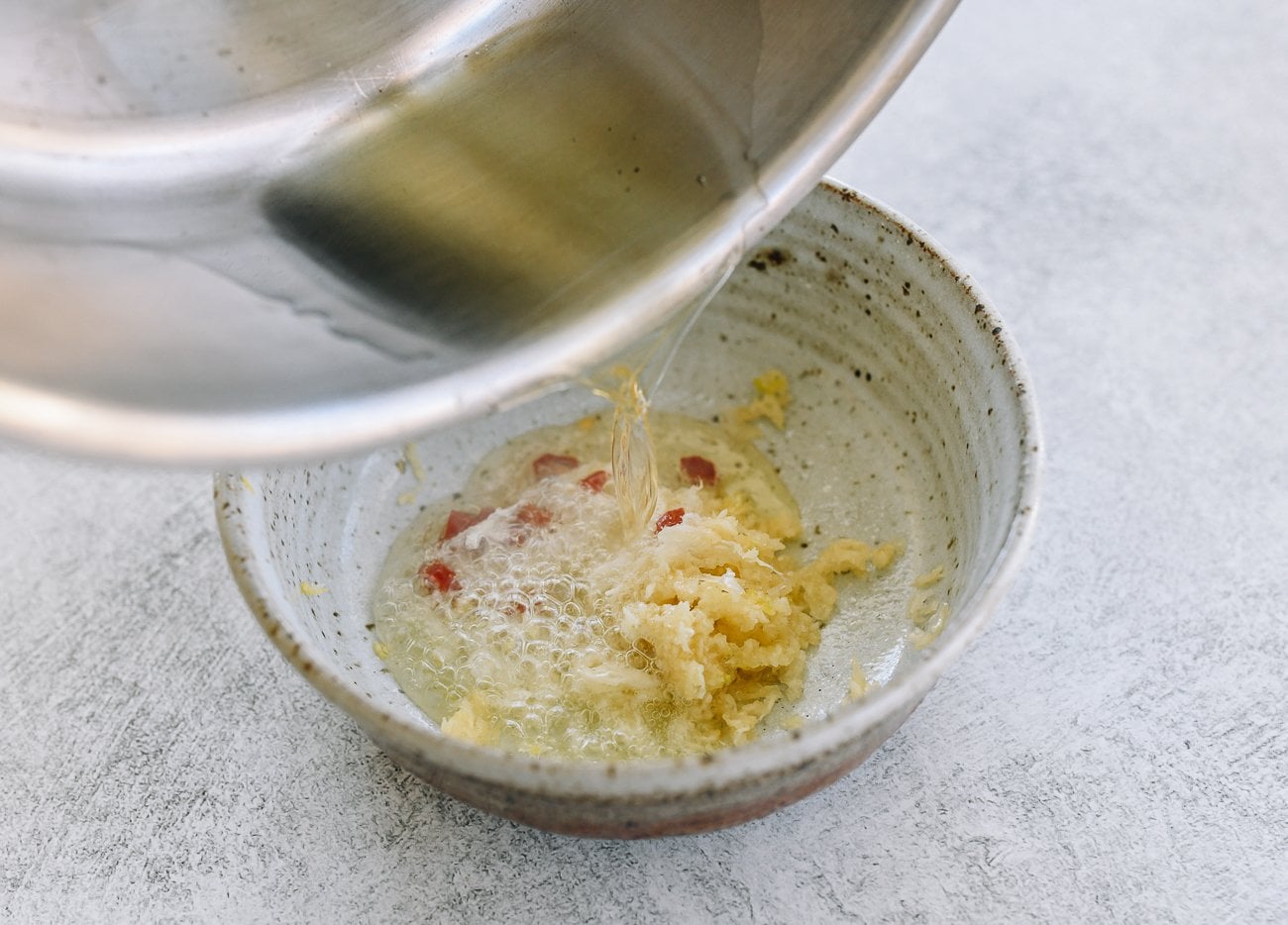 pouring hot oil over garlic and chilies