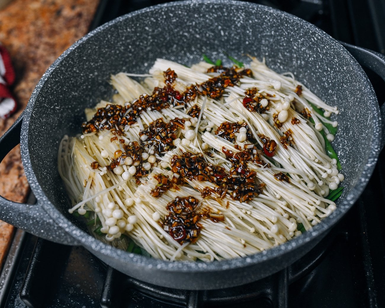 sauce poured over enoki mushrooms