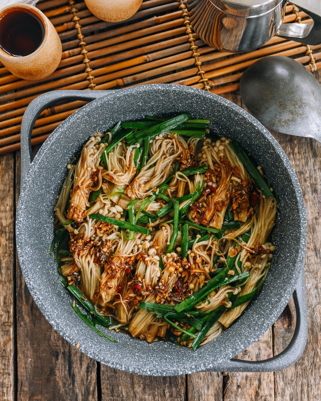 Spicy enoki mushrooms with garlic chives in pan