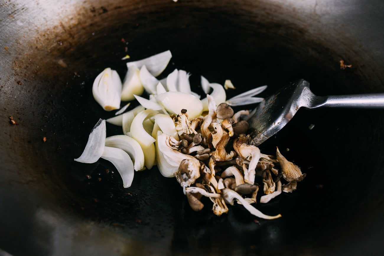 oyster mushrooms and sliced onion in wok