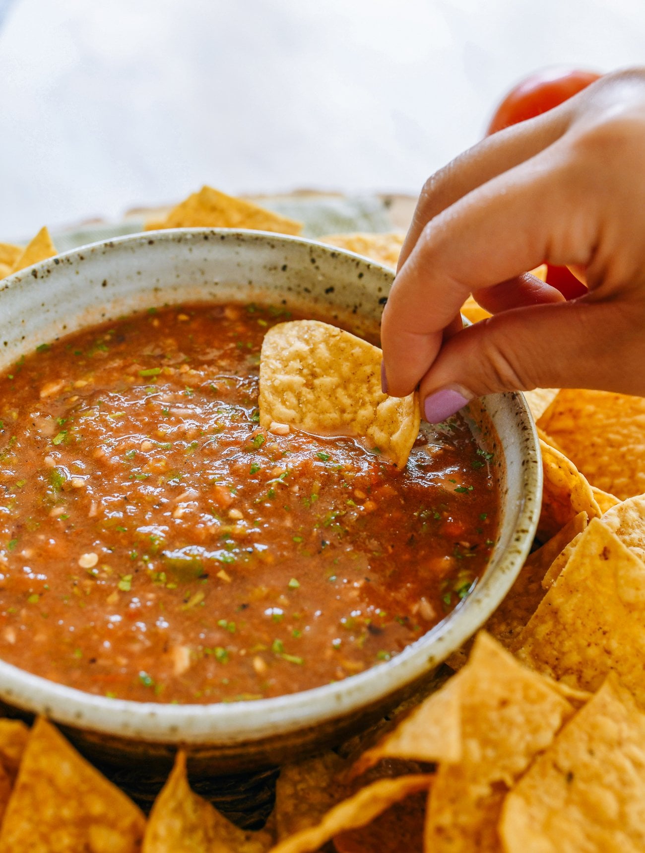 dunking tortilla chip into salsa