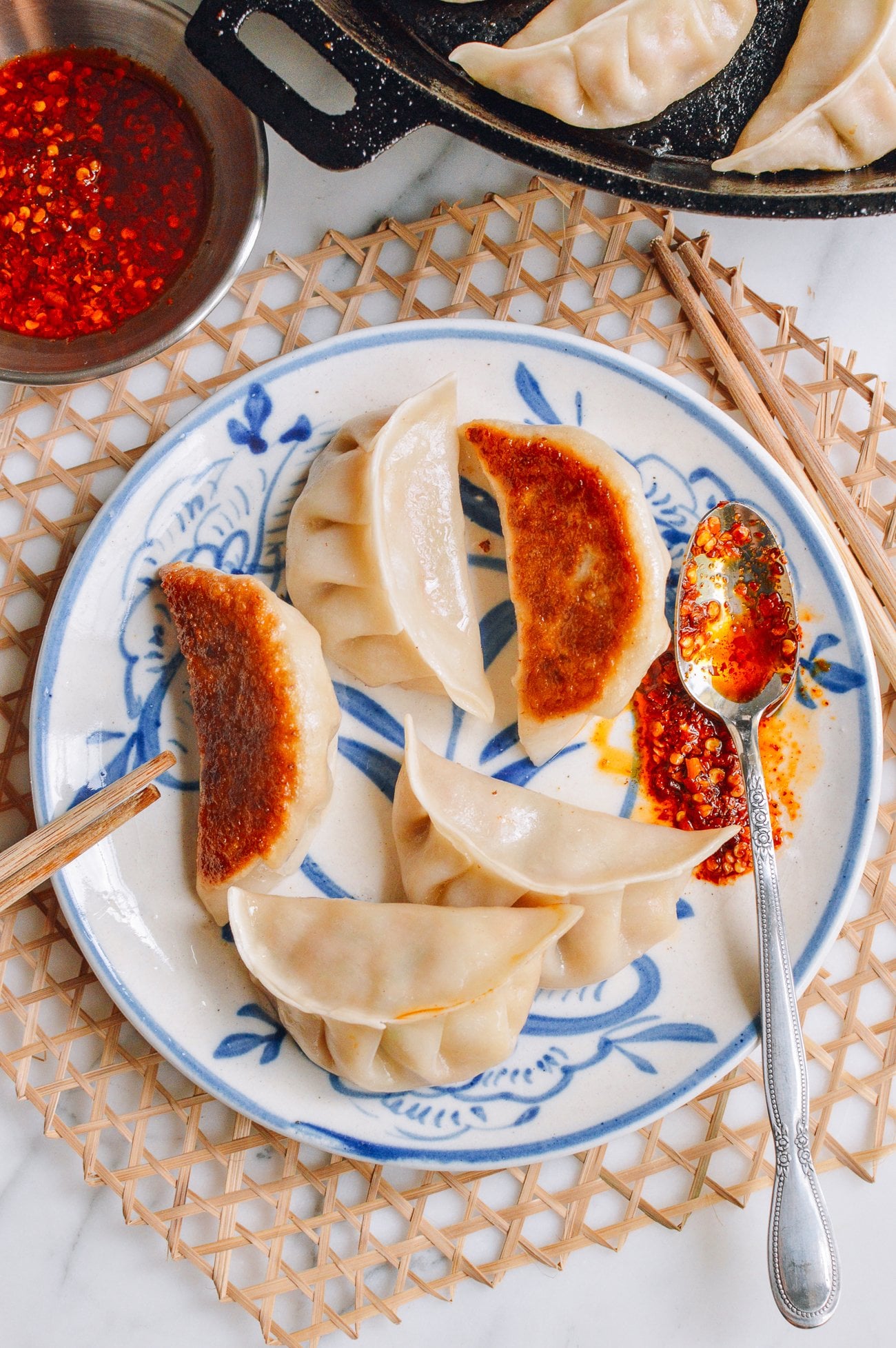 pan-fried chicken zucchini dumplings on plate with chili oil