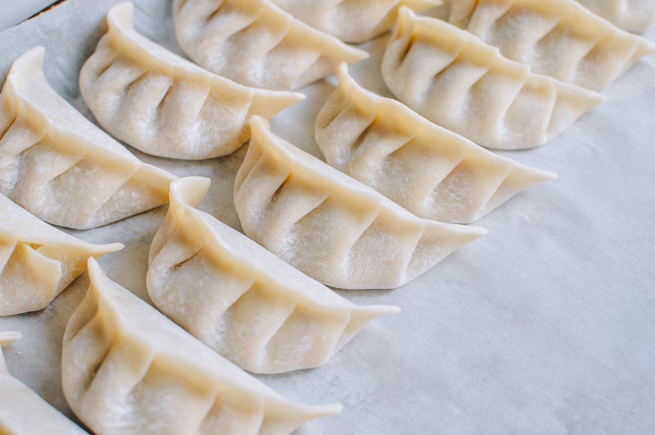 folded dumplings on sheet pan with parchment paper