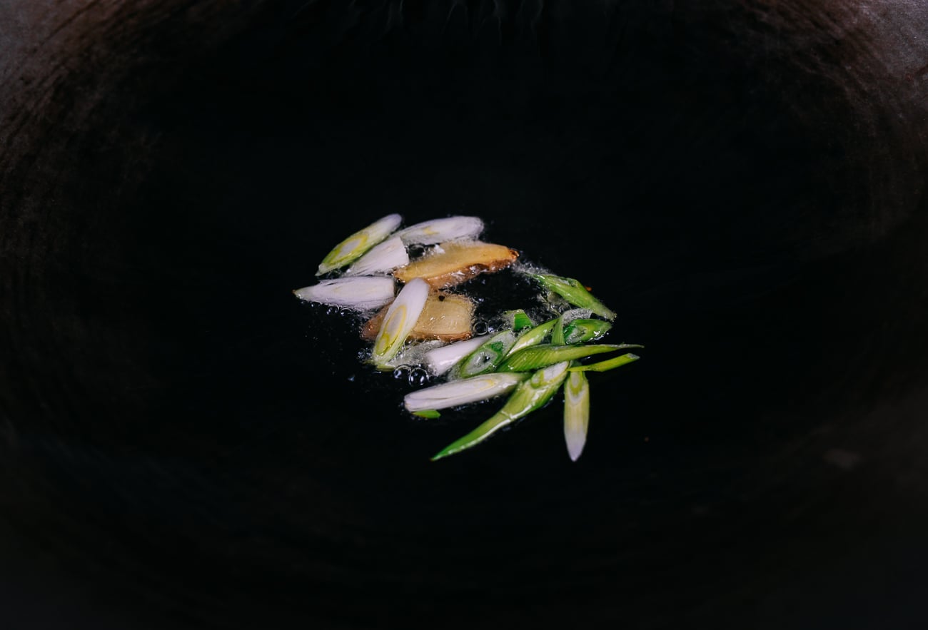 ginger and white parts of scallions in wok