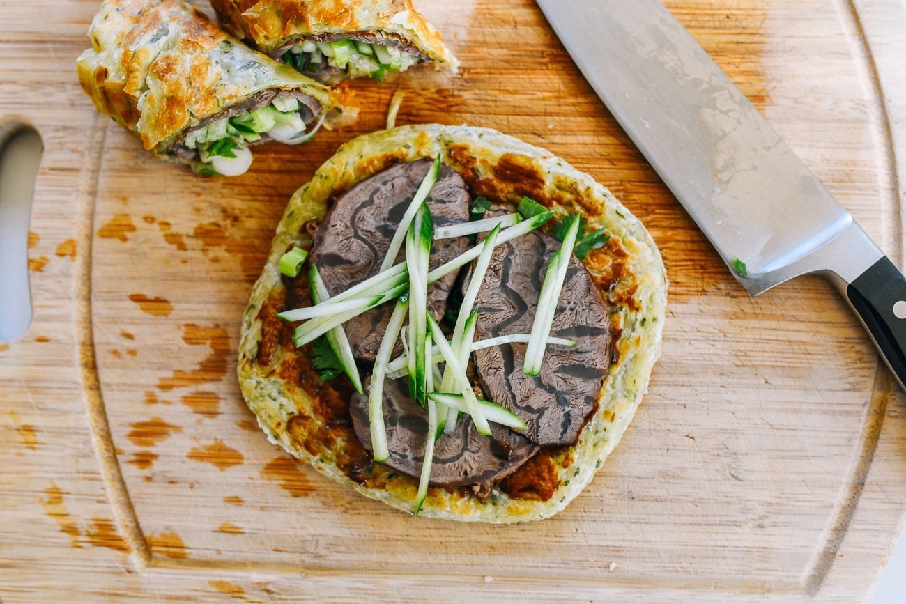 julienned cucumber on sliced beef shank on scallion pancake