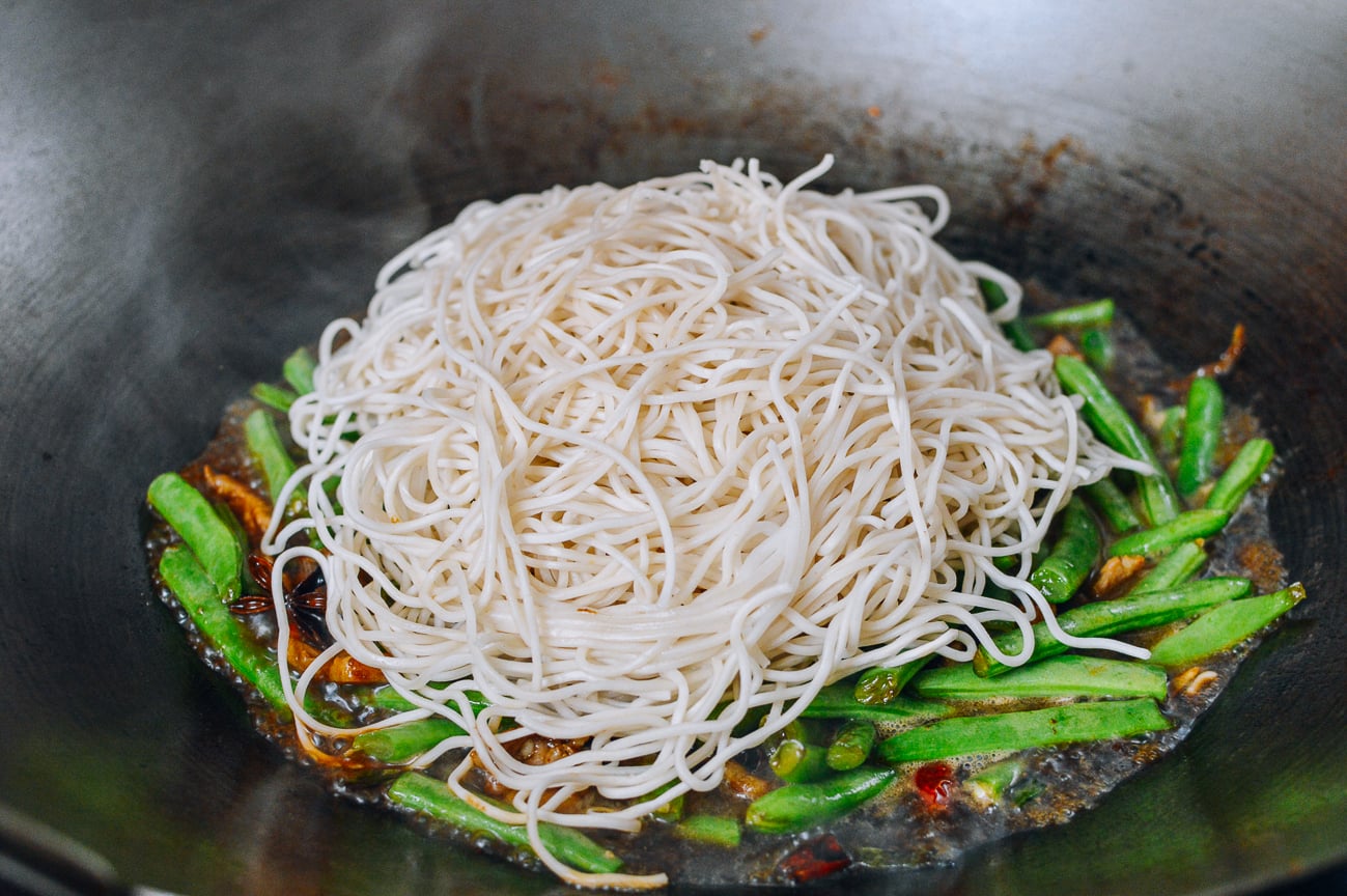 adding noodles to green beans