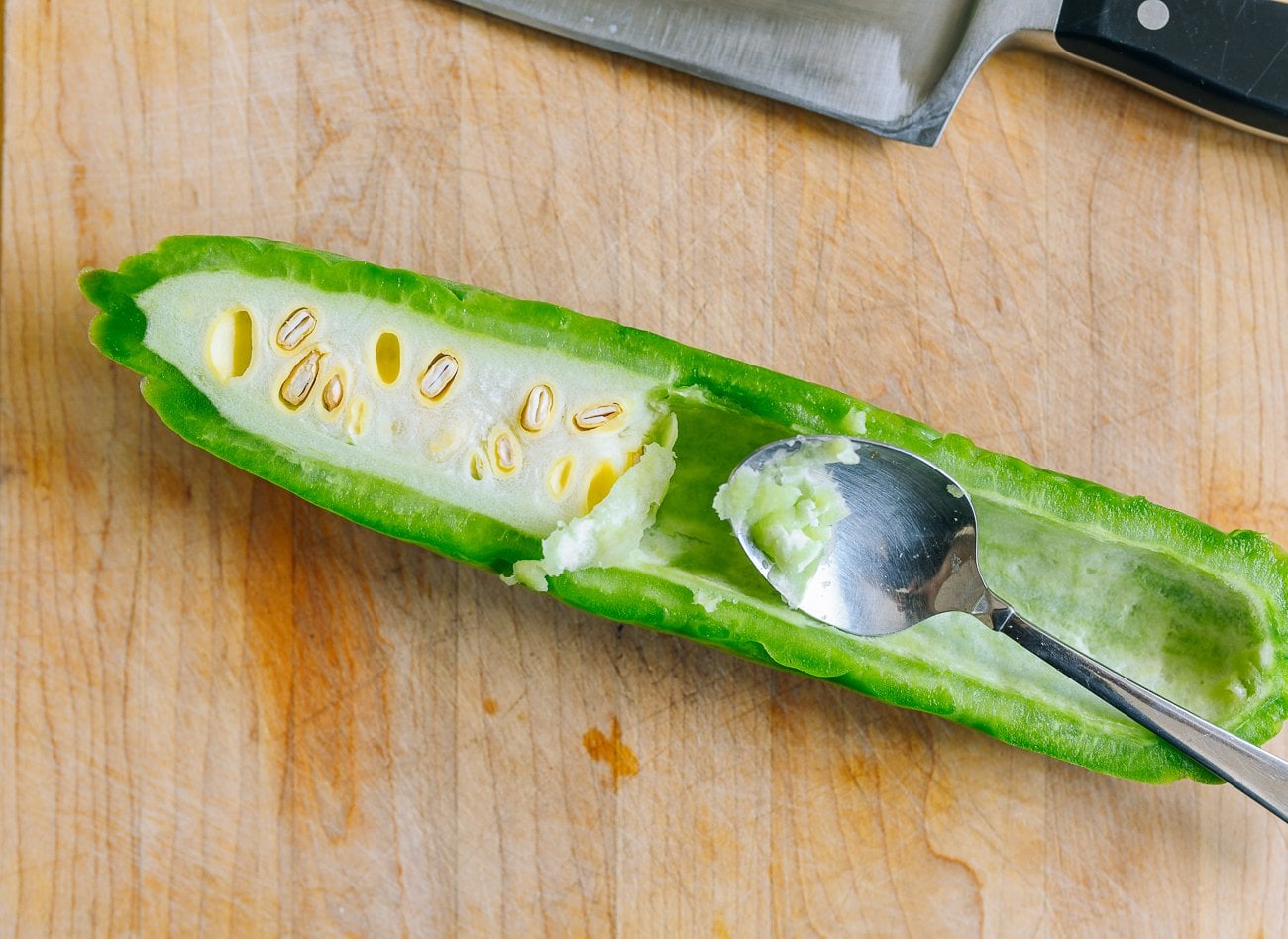 scooping seeds out of bitter melon