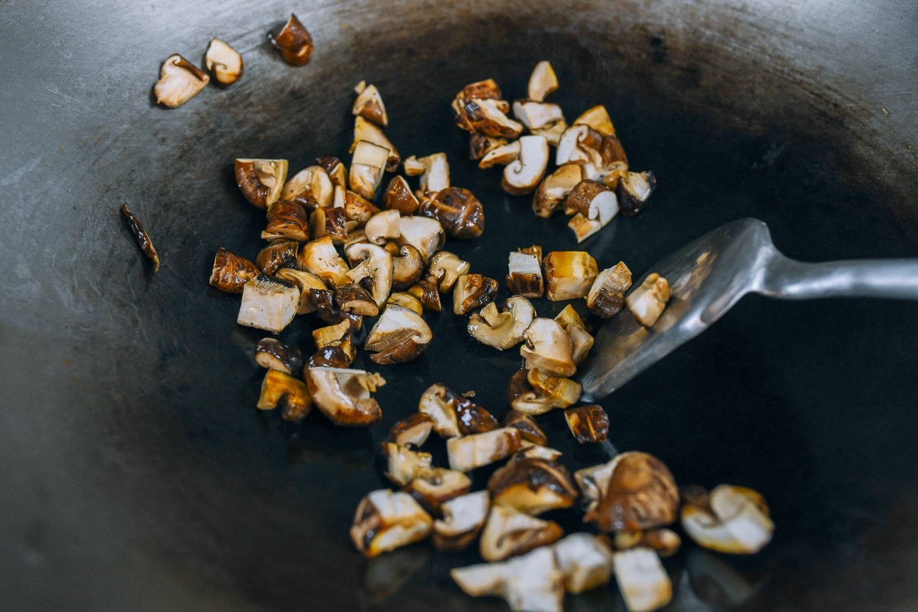 stir-frying diced mushrooms in wok