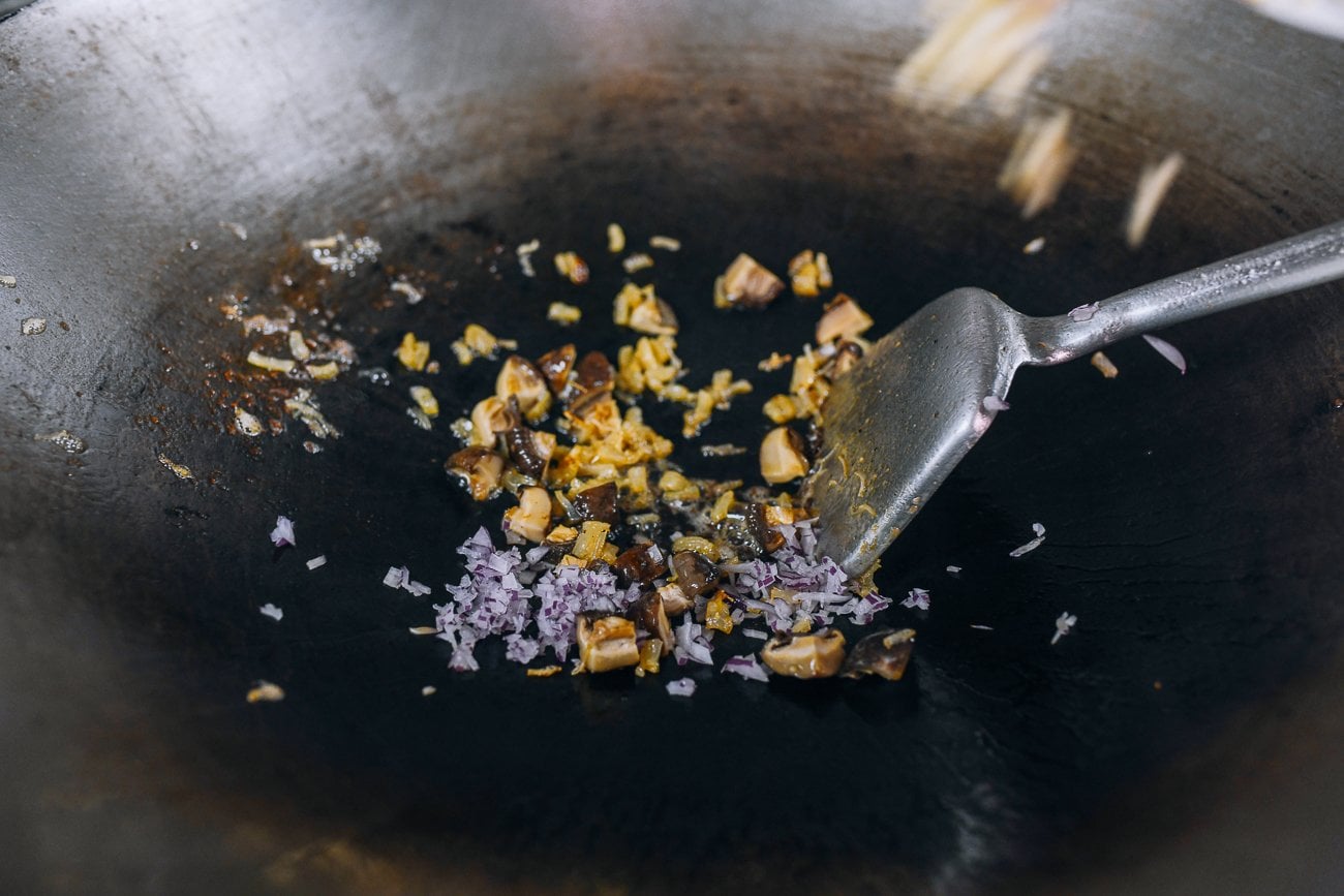 adding shallots and garlic to dried scallop and mushroom
