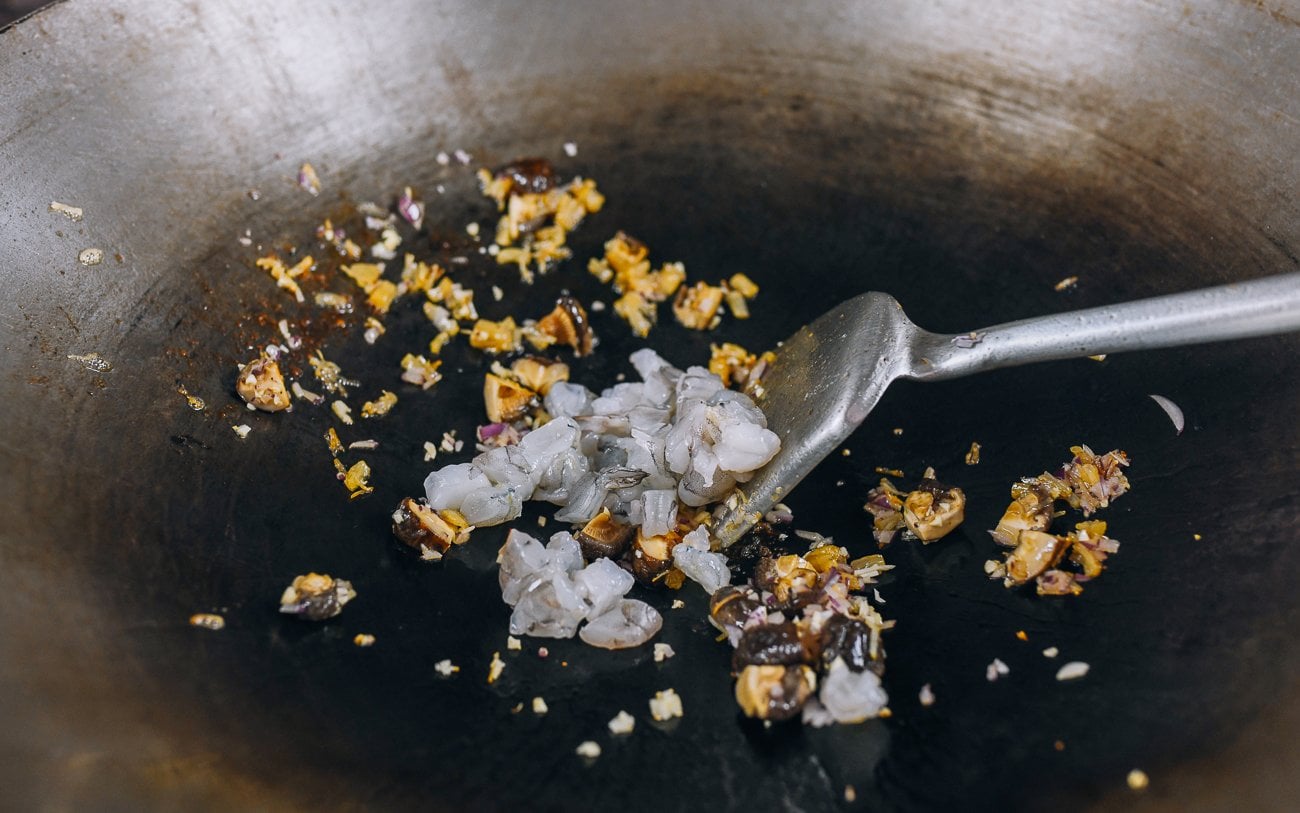 adding shrimp to wok