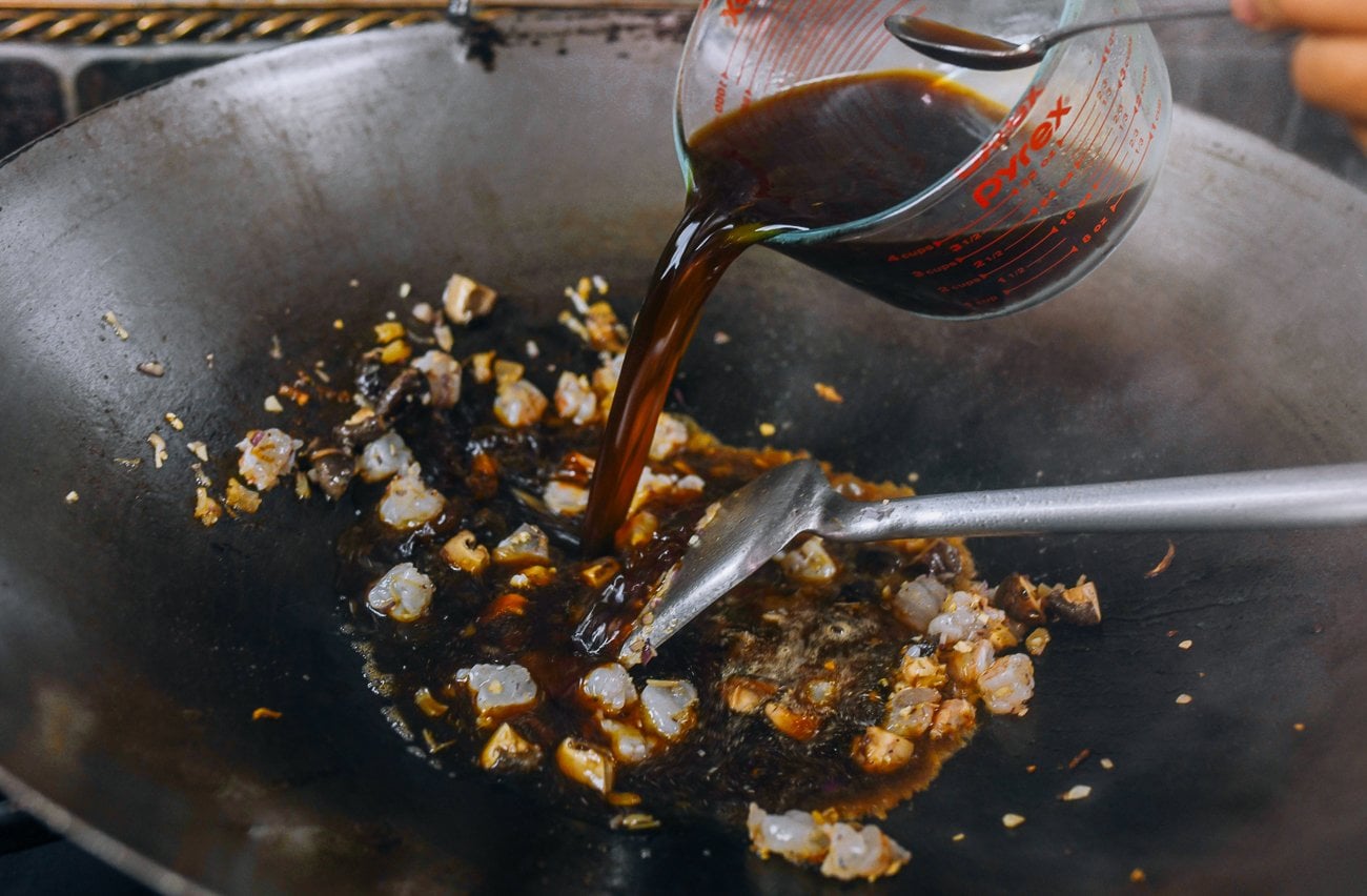 adding sauce base to wok