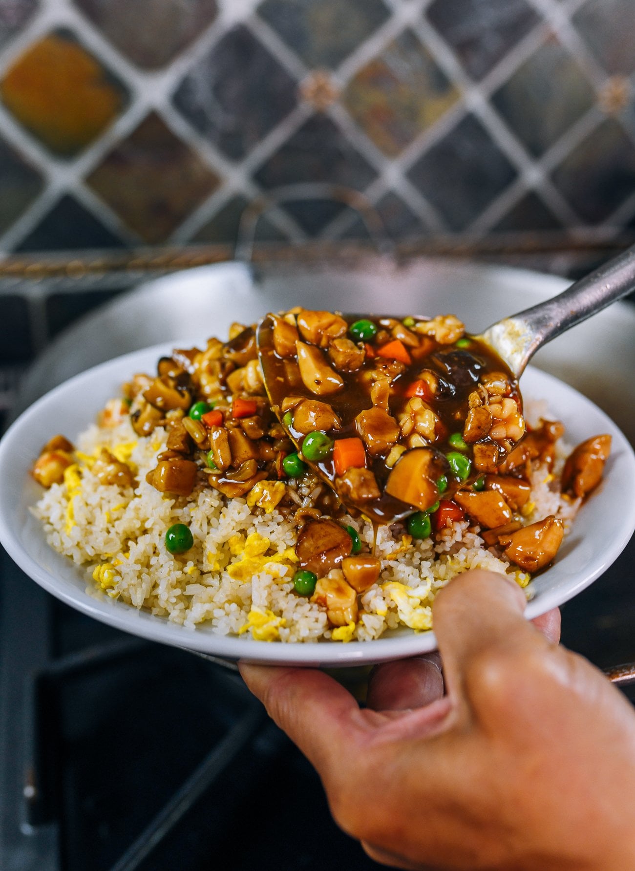 scooping sauce mixture onto fried rice
