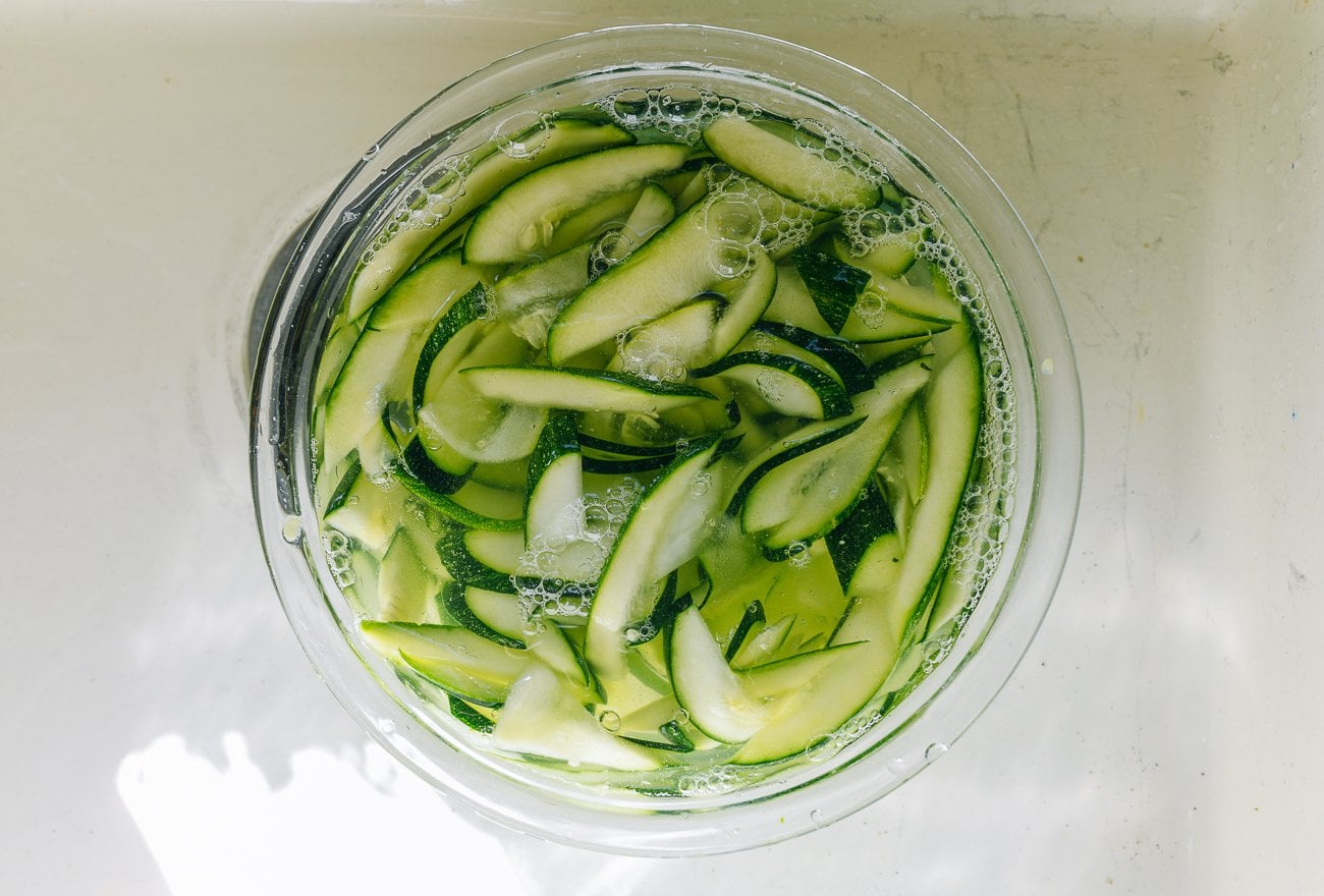 rinsing zucchini slices in glass bowl