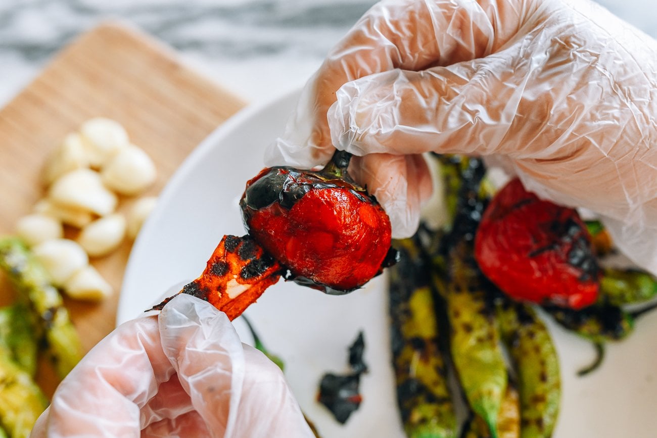peeling away charred skin of peppers