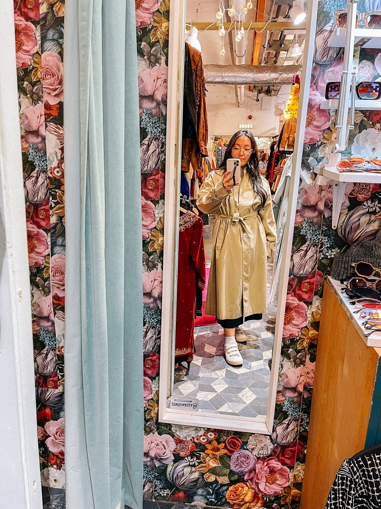 Trying on a vintage trenchcoat in the mirror