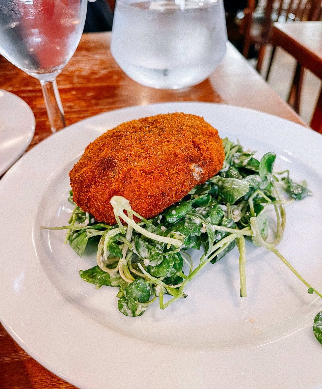 Beef hash patty, deep fried over green salad
