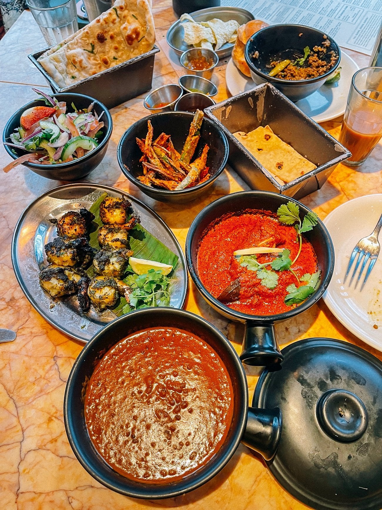 Spread at dishoom of okra fries, curries, shrimp, salad, and parathas