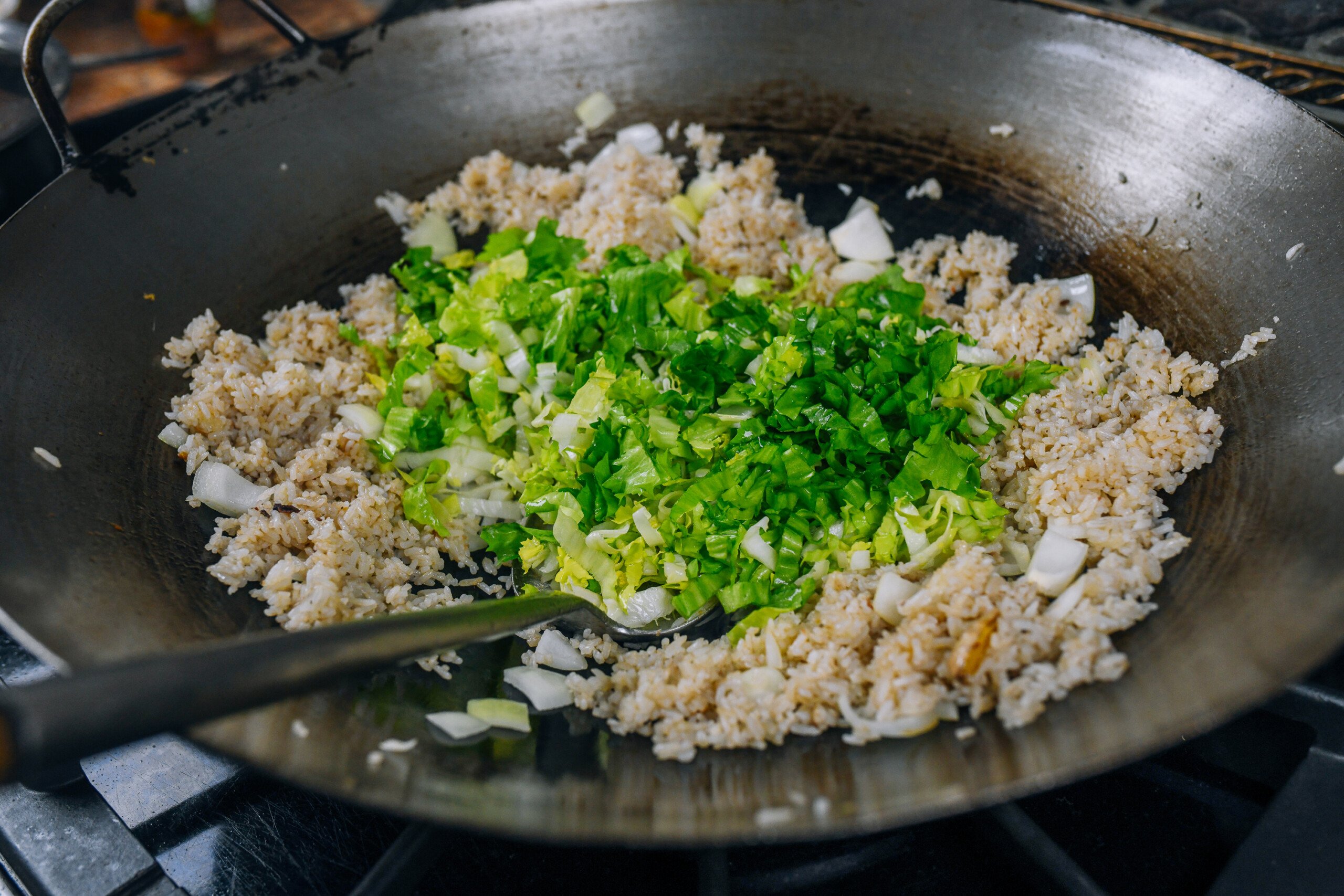 adding lettuce to fried rice