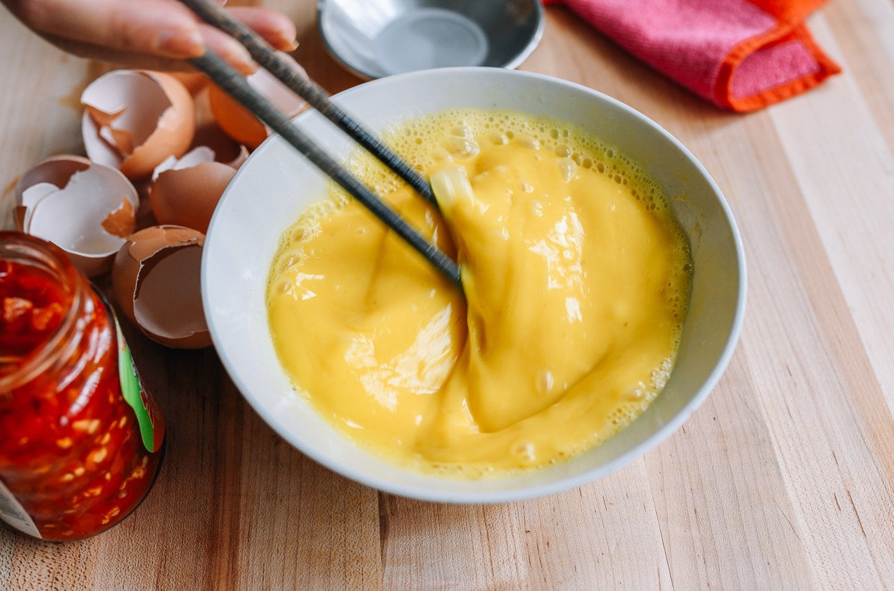 beating eggs in bowl with chopsticks