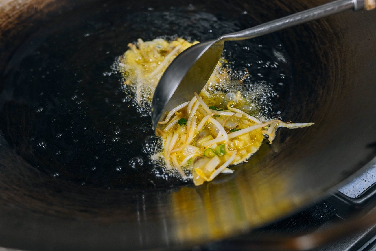 dropping egg foo young batter into oil