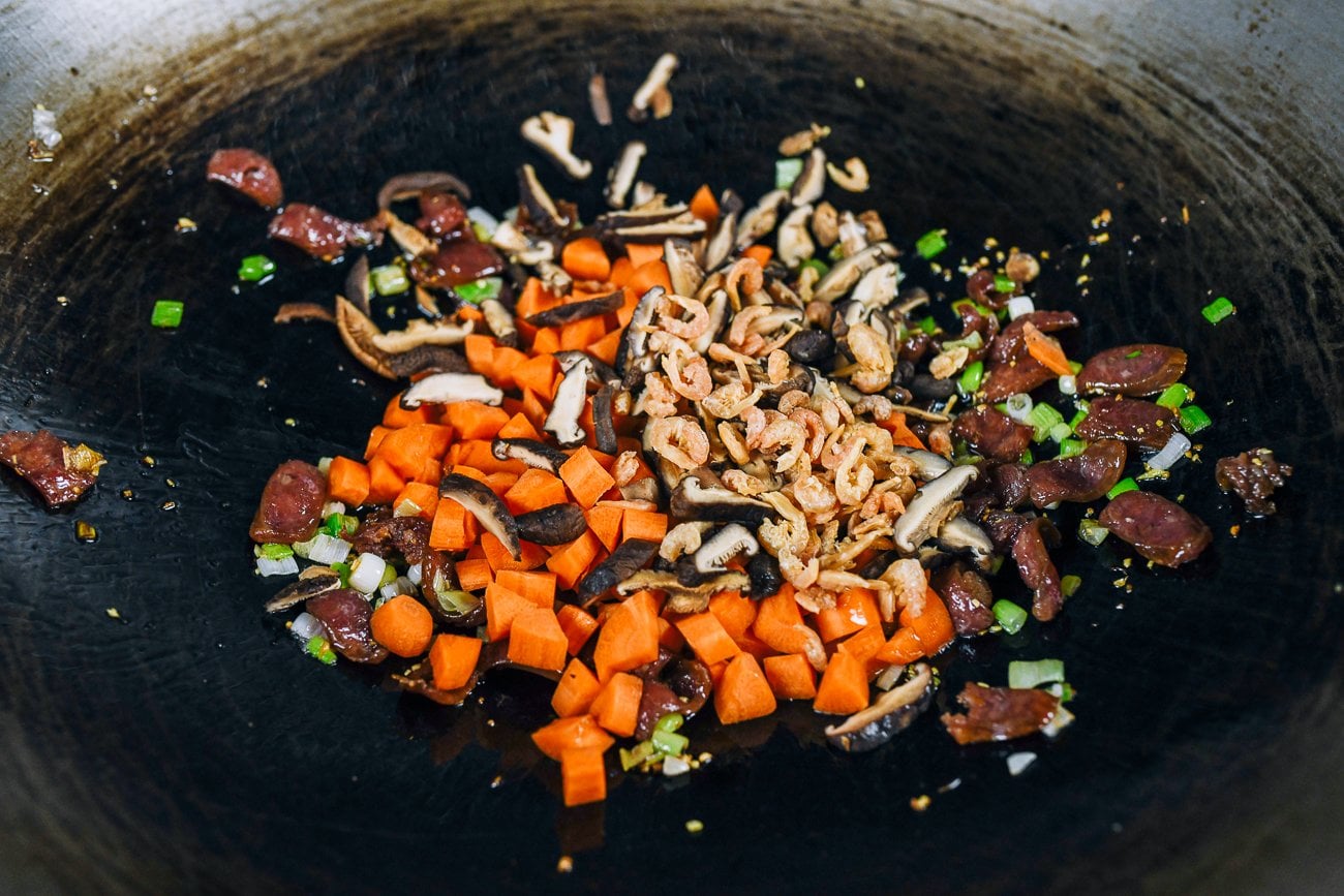 carrots, mushrooms, dried shrimp, Chinese sausage, and scallions in wok