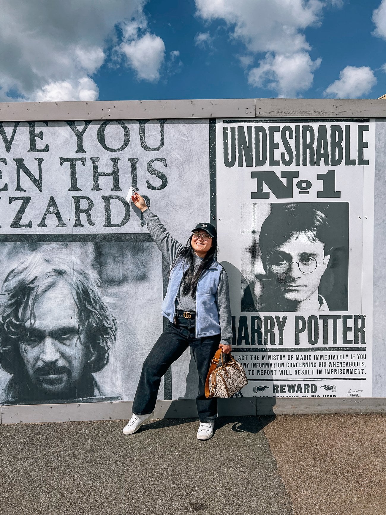 Kaitlin posing in front of Harry Potter wall with Undesirable No. 1 Harry Potter and insane wanted wizard Sirius Black