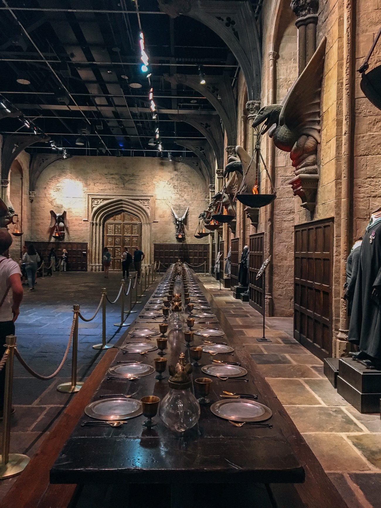 The Great Hall, lined with student place settings of brass goblets and silver plates