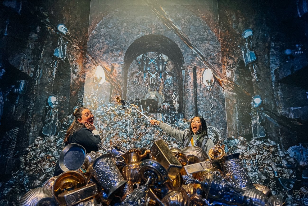 Kaitlin and Kim take a photo in the Lestrange vault with the sword and Hufflepuff cup