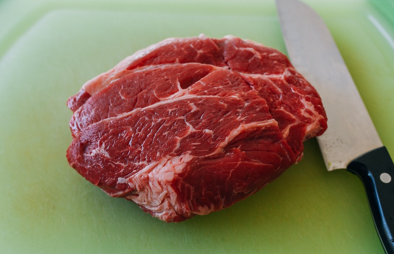 piece of boneless beef chuck on green plastic cutting board