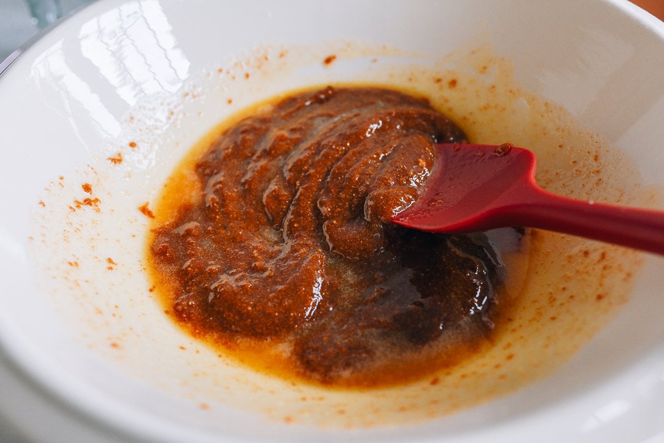 mixing melted butter, date sugar, and date syrup in bowl
