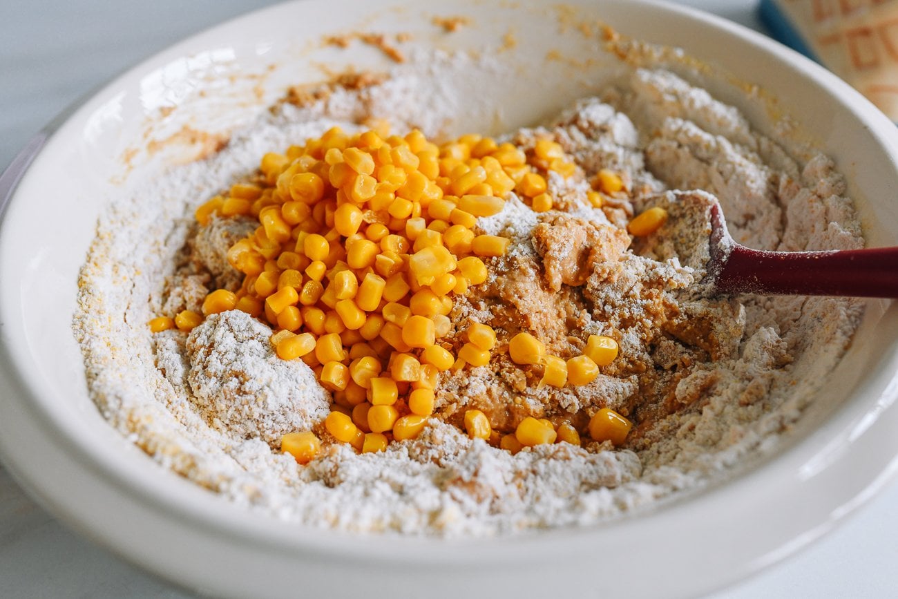 adding corn to cornbread batter